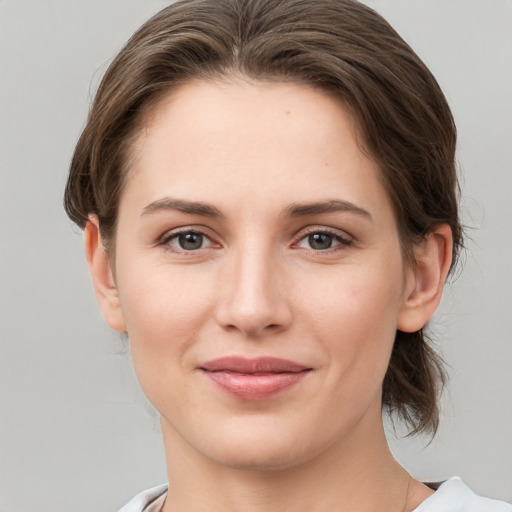 Joyful white young-adult female with medium  brown hair and grey eyes