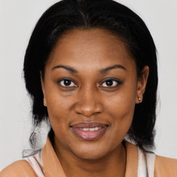 Joyful black adult female with medium  brown hair and brown eyes