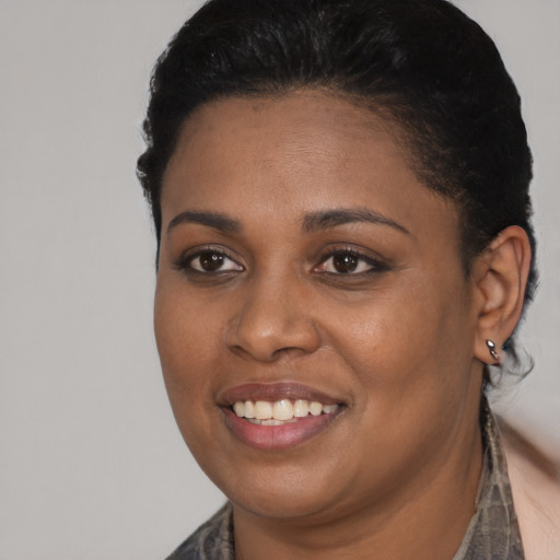 Joyful black young-adult female with short  black hair and brown eyes