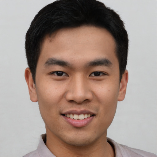 Joyful asian young-adult male with short  black hair and brown eyes