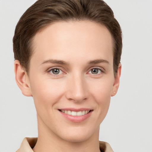 Joyful white young-adult female with short  brown hair and grey eyes