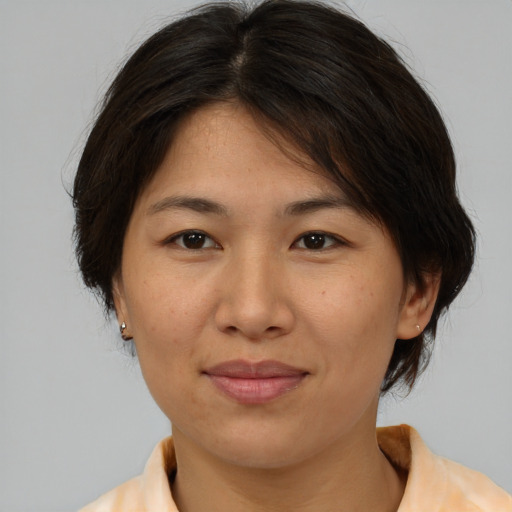 Joyful asian adult female with medium  brown hair and brown eyes