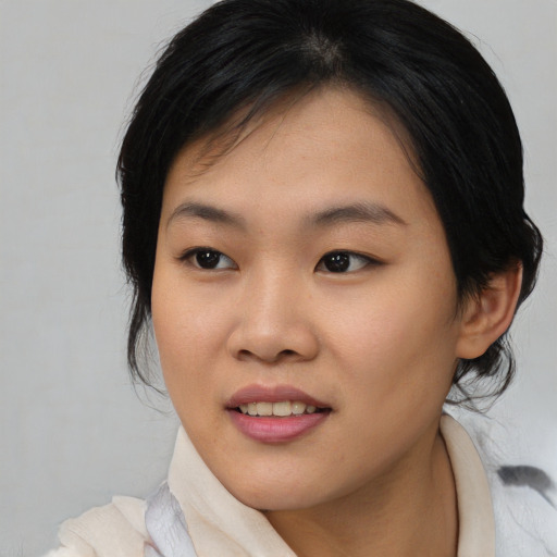 Joyful asian young-adult female with medium  black hair and brown eyes