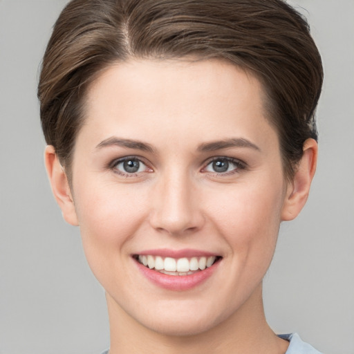 Joyful white young-adult female with short  brown hair and grey eyes