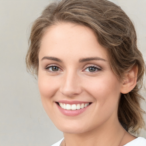 Joyful white young-adult female with medium  brown hair and green eyes