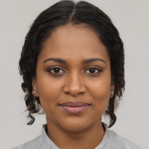 Joyful black young-adult female with medium  brown hair and brown eyes