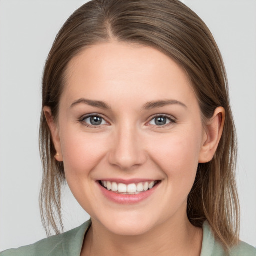 Joyful white young-adult female with medium  brown hair and grey eyes