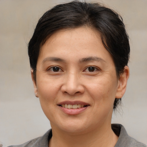 Joyful white adult female with medium  brown hair and brown eyes
