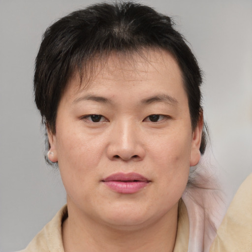 Joyful asian adult female with medium  brown hair and brown eyes