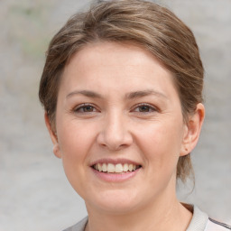 Joyful white young-adult female with medium  brown hair and grey eyes