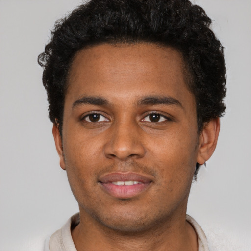 Joyful black young-adult male with short  black hair and brown eyes