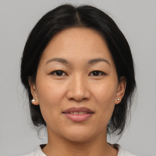 Joyful asian adult female with medium  black hair and brown eyes