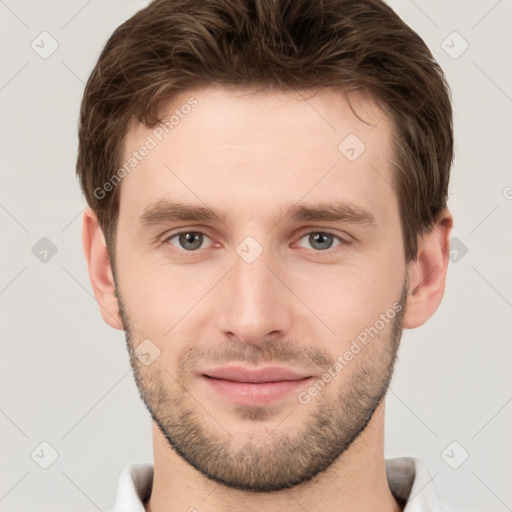 Joyful white young-adult male with short  brown hair and grey eyes