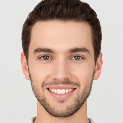 Joyful white young-adult male with short  brown hair and brown eyes