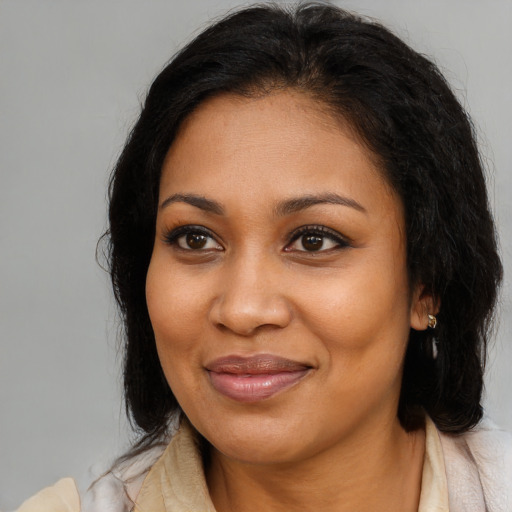 Joyful black adult female with long  brown hair and brown eyes