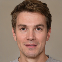 Joyful white young-adult male with short  brown hair and grey eyes