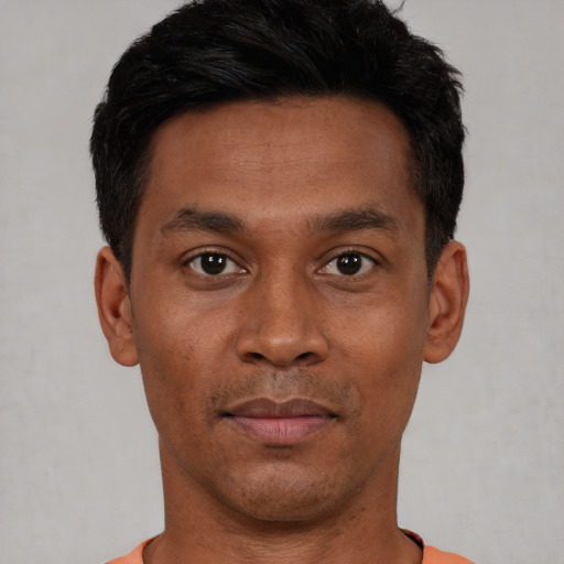 Joyful black young-adult male with short  black hair and brown eyes
