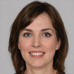 Joyful white young-adult female with medium  brown hair and grey eyes