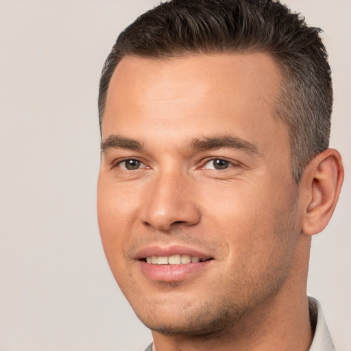 Joyful white young-adult male with short  brown hair and brown eyes