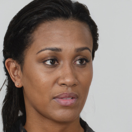 Joyful black young-adult female with long  brown hair and brown eyes