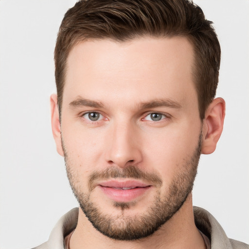 Joyful white young-adult male with short  brown hair and grey eyes