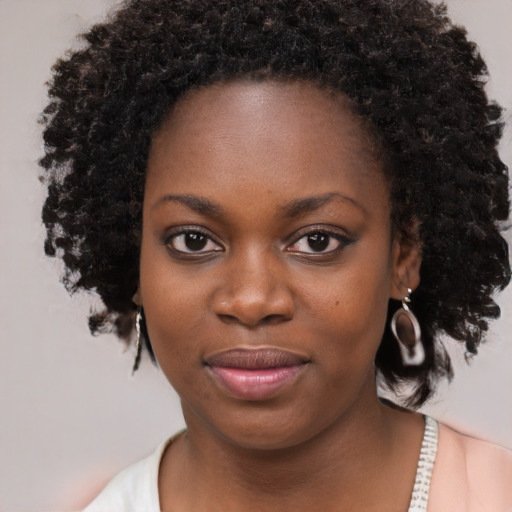 Joyful black young-adult female with medium  brown hair and brown eyes