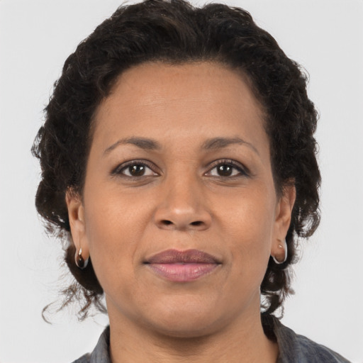 Joyful latino adult female with medium  brown hair and brown eyes
