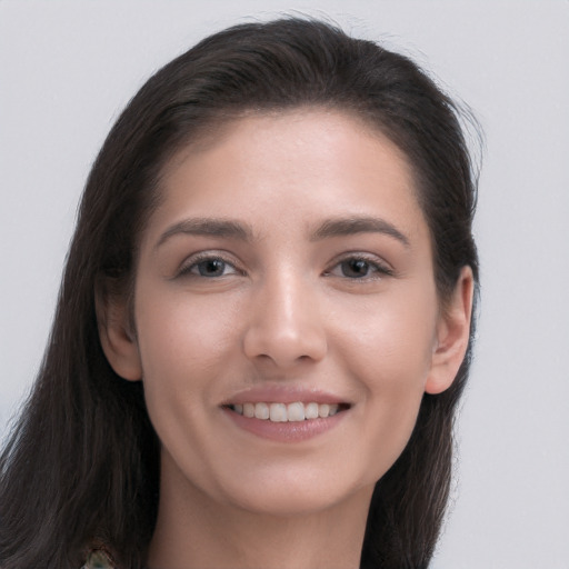 Joyful white young-adult female with long  brown hair and brown eyes