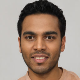 Joyful latino young-adult male with short  black hair and brown eyes