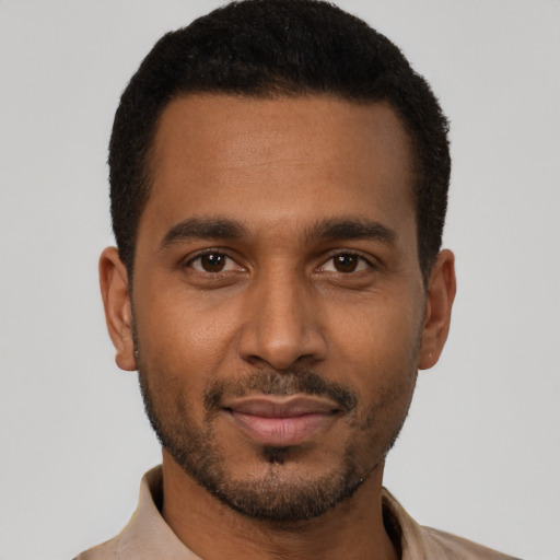 Joyful black young-adult male with short  black hair and brown eyes