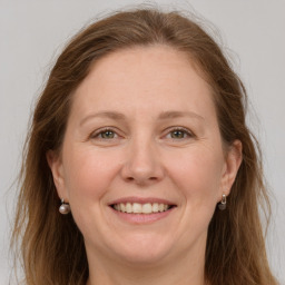 Joyful white adult female with long  brown hair and grey eyes