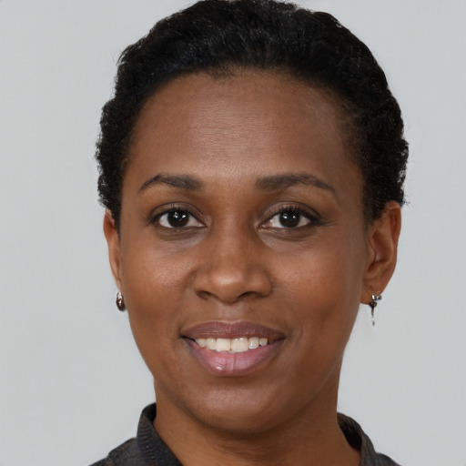 Joyful black adult female with short  brown hair and brown eyes