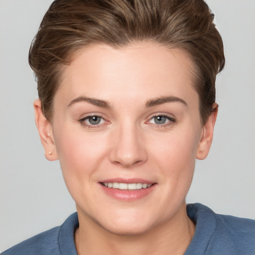 Joyful white young-adult female with short  brown hair and grey eyes