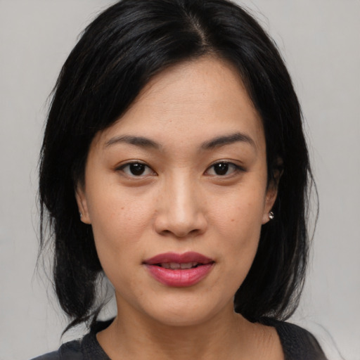 Joyful asian young-adult female with medium  black hair and brown eyes