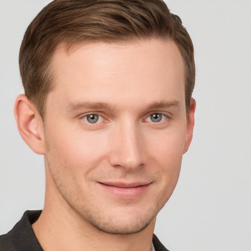 Joyful white young-adult male with short  brown hair and grey eyes