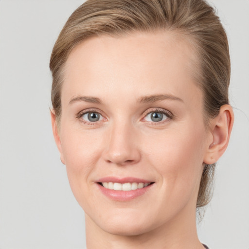 Joyful white young-adult female with medium  brown hair and blue eyes