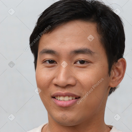 Joyful asian young-adult male with short  brown hair and brown eyes