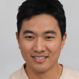 Joyful asian young-adult male with short  black hair and brown eyes