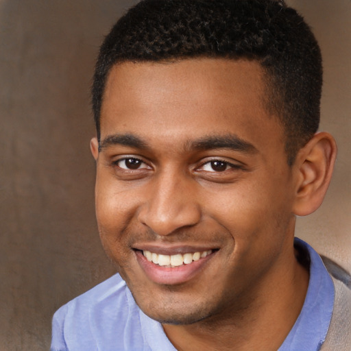 Joyful black young-adult male with short  brown hair and brown eyes