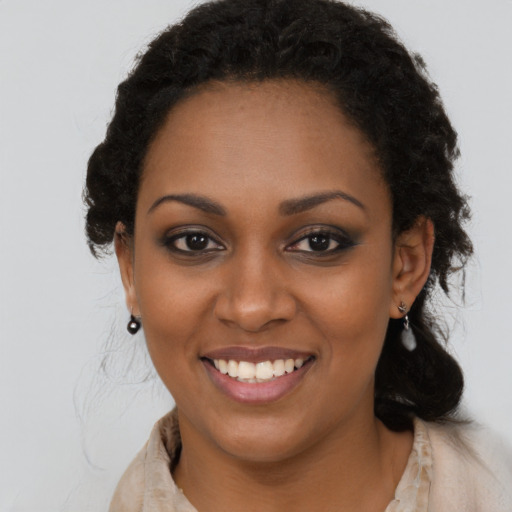 Joyful black young-adult female with long  black hair and brown eyes