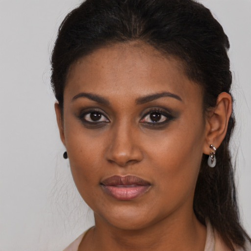 Joyful black young-adult female with long  brown hair and brown eyes