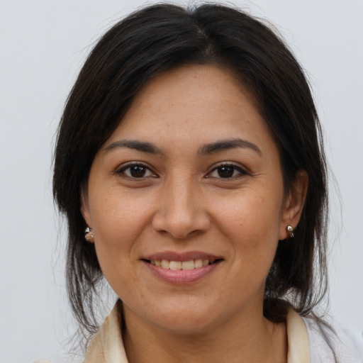 Joyful latino adult female with long  brown hair and brown eyes