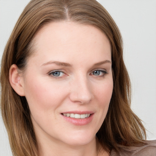 Joyful white young-adult female with long  brown hair and blue eyes