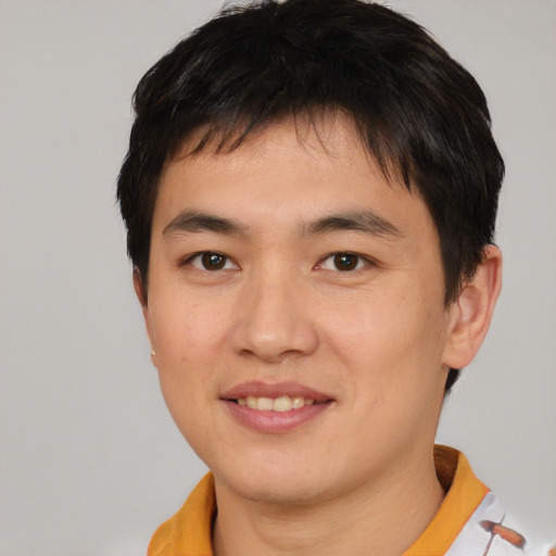 Joyful asian young-adult male with short  black hair and brown eyes