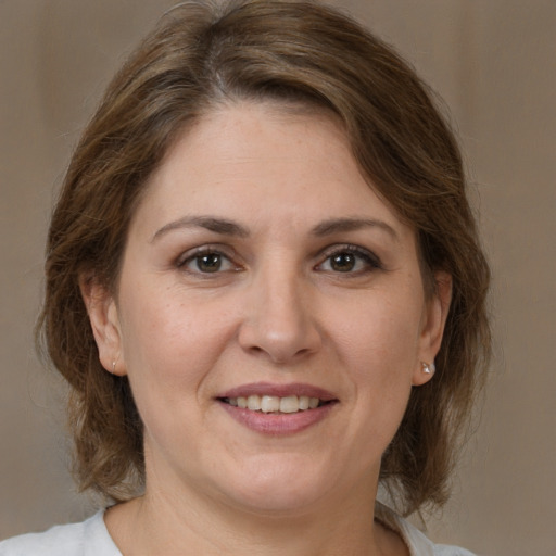 Joyful white adult female with medium  brown hair and brown eyes