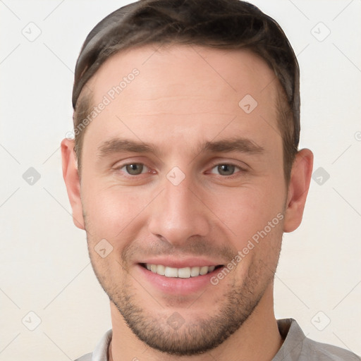 Joyful white young-adult male with short  brown hair and brown eyes