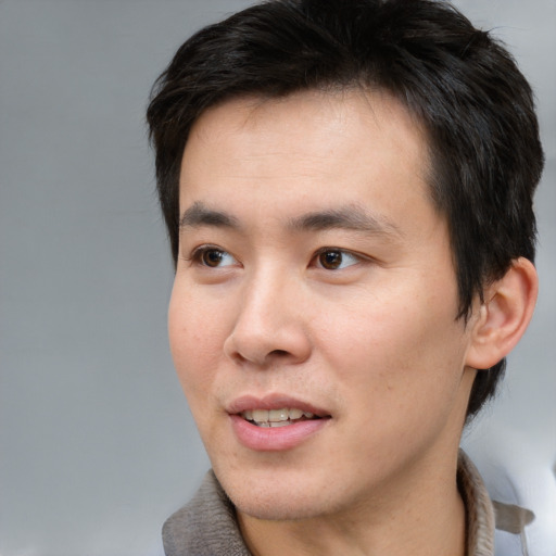 Joyful asian young-adult male with short  brown hair and brown eyes