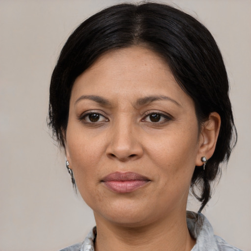 Joyful latino adult female with medium  black hair and brown eyes