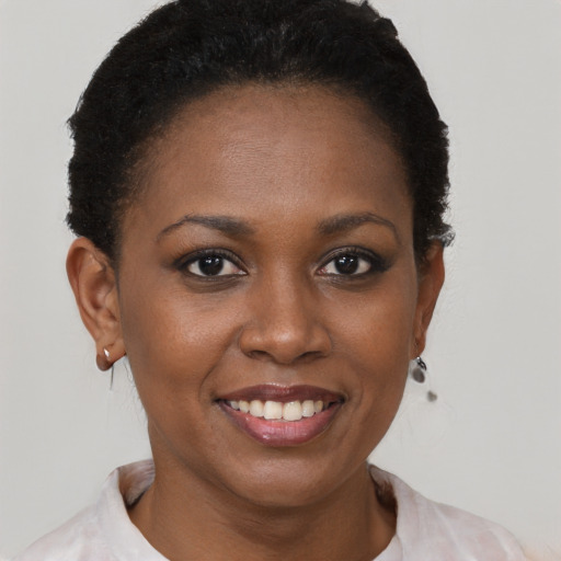 Joyful black young-adult female with short  brown hair and brown eyes