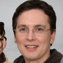 Joyful white adult male with medium  brown hair and brown eyes